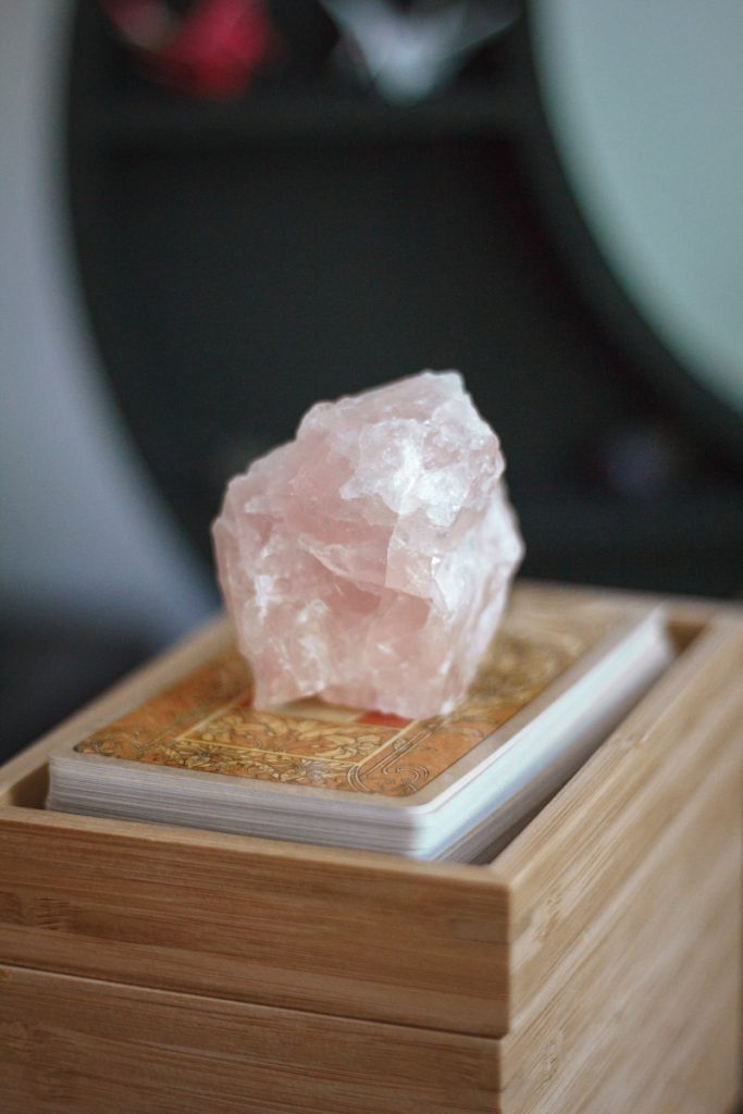 rose quartz crystal on brown wooden table